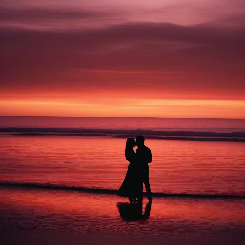 A couple embracing on a beach at sunset.